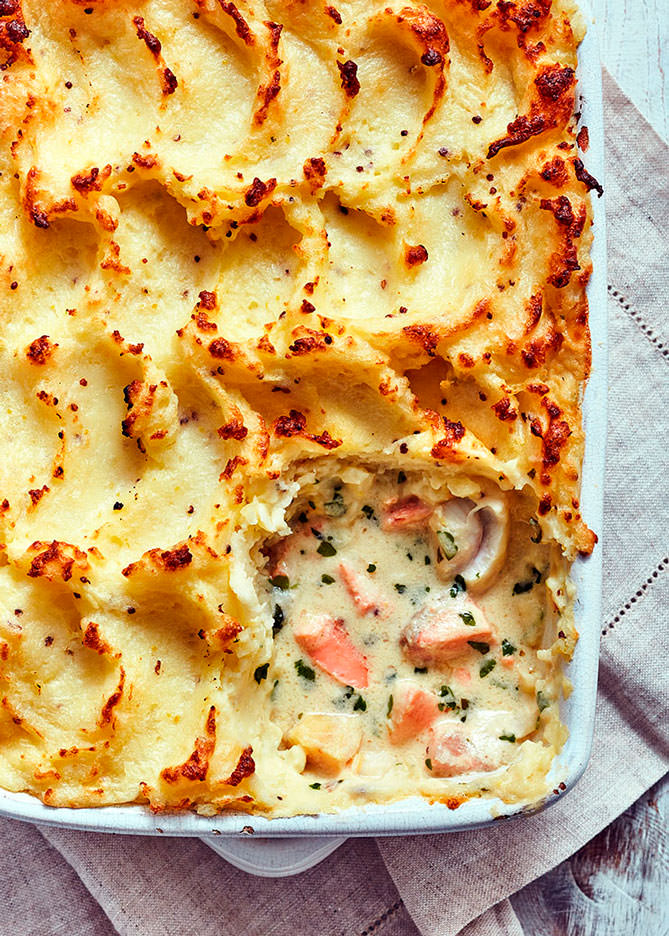Creamy fish pie with a scoop out showing the content of the pie - London Food & Drinks Photographer