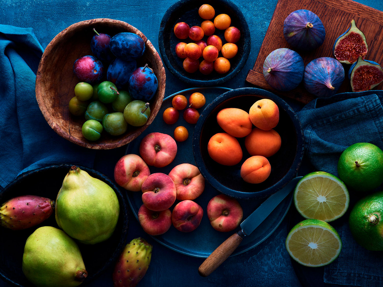 Finefood specialists fruit range on a blue backdrop and wooden boards
