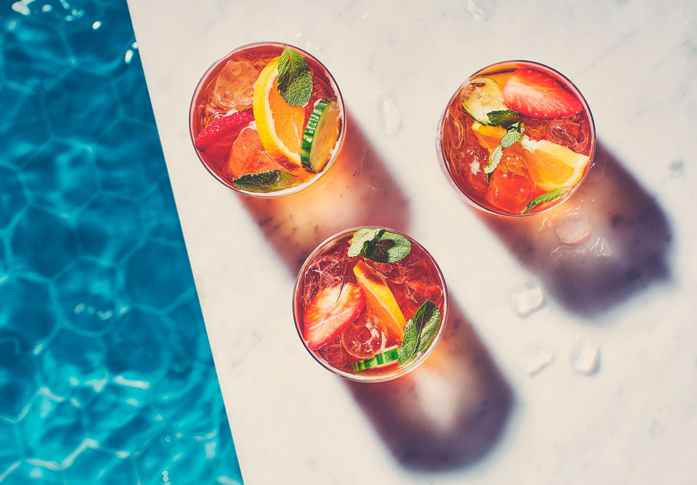 Glasses of Pimms next to a swimming pool -  London Food & Drinks Photographer