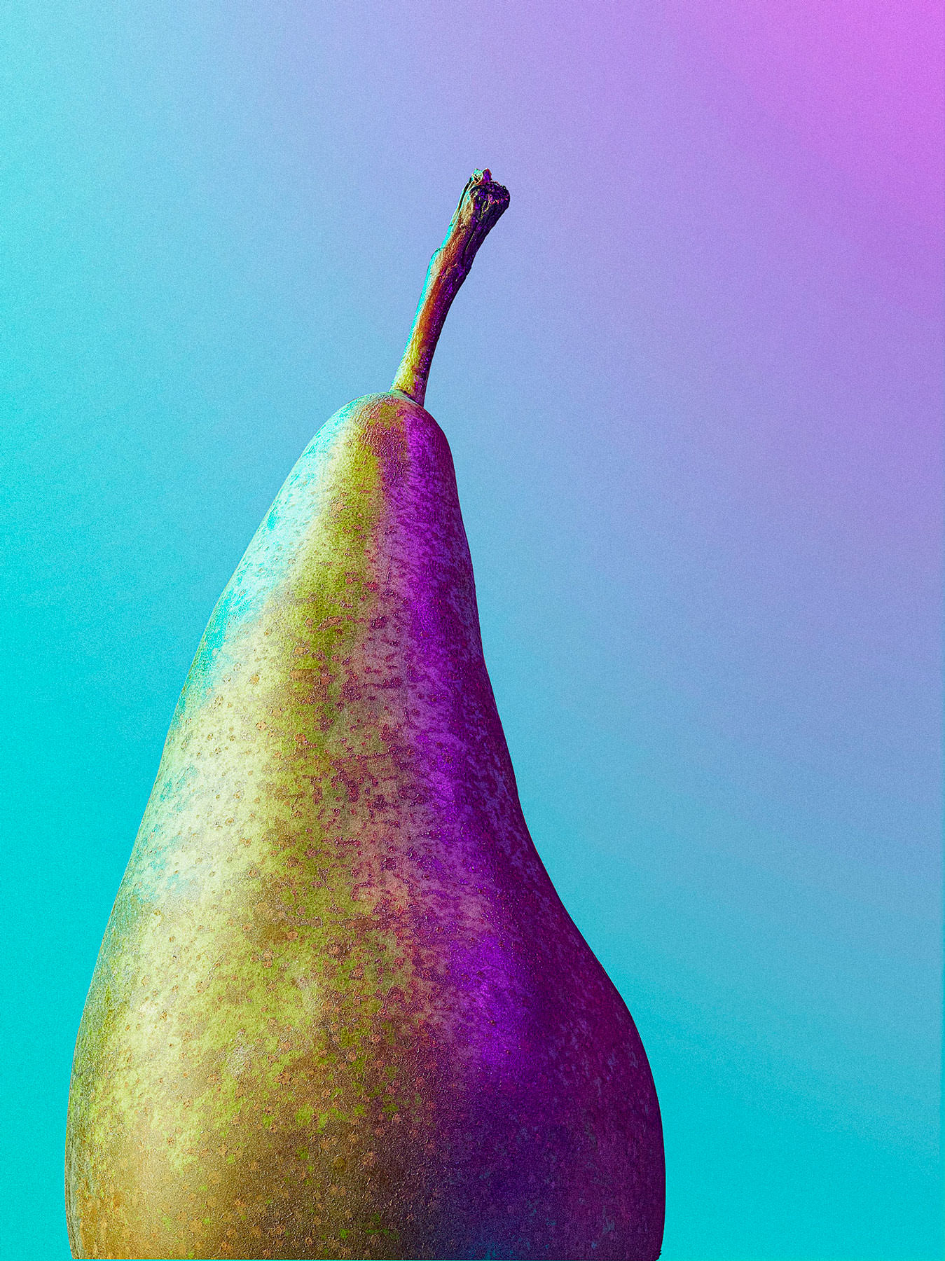 closeup of a pear lit with coloured gels on a blue and pink backdrop - London Food & Drinks Photographer
