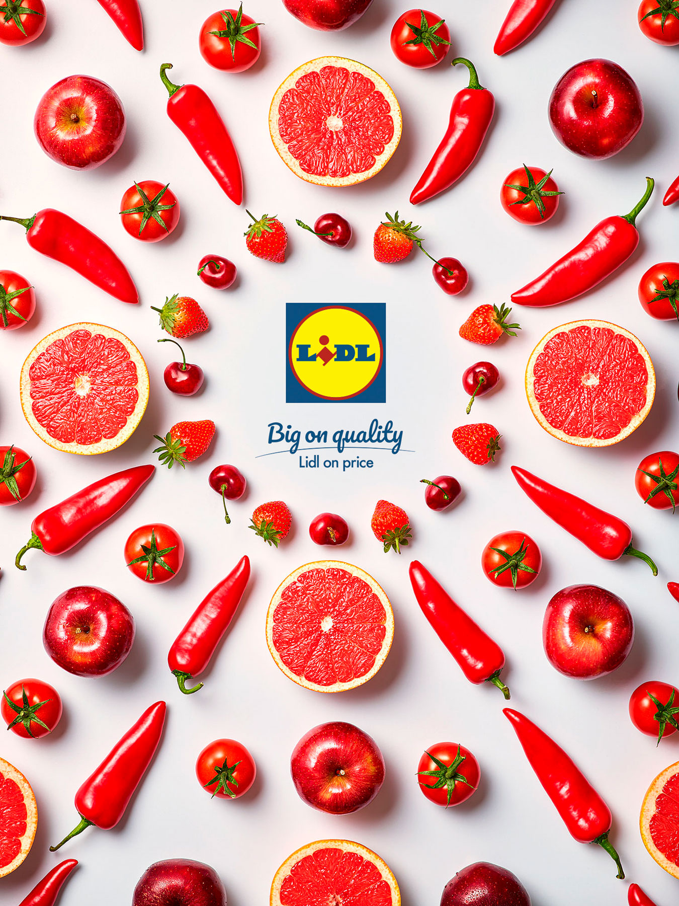 Red Chillis, red grapefruit, red apples, and tomatoes arranged graphically in a spiral with lidl logo in the middle. - London Food & Drinks Photographer