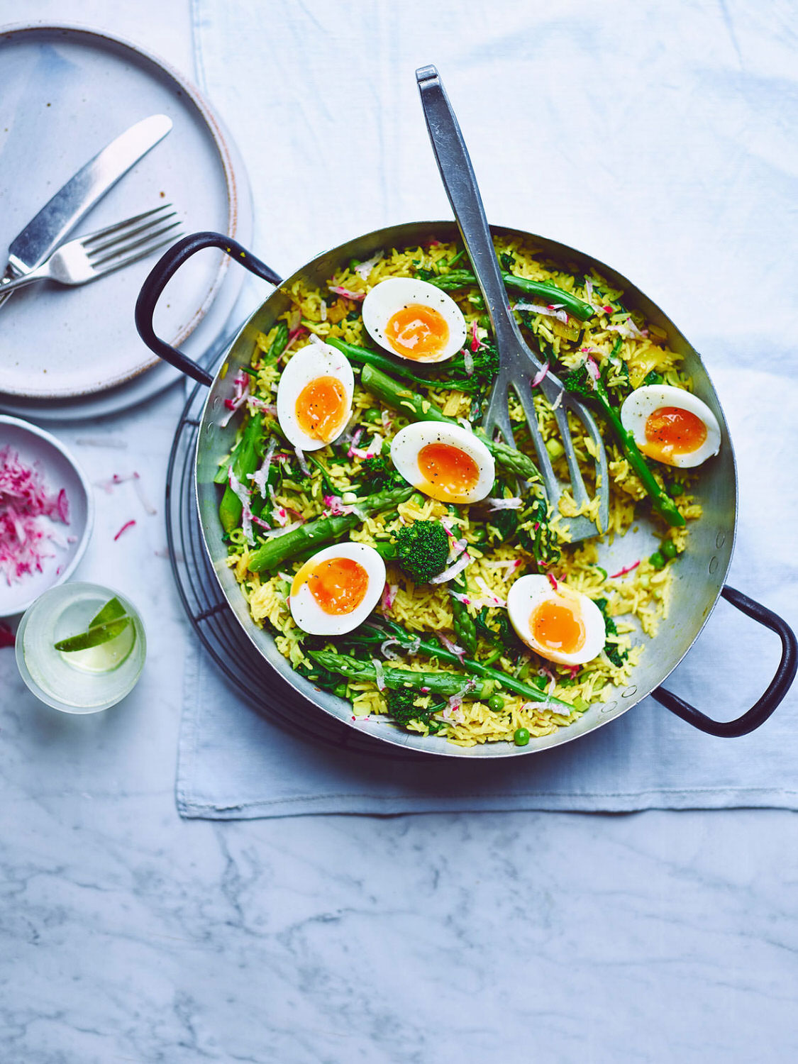 Kedgeree in a skillet pan with handles on a light blue kitchen surface